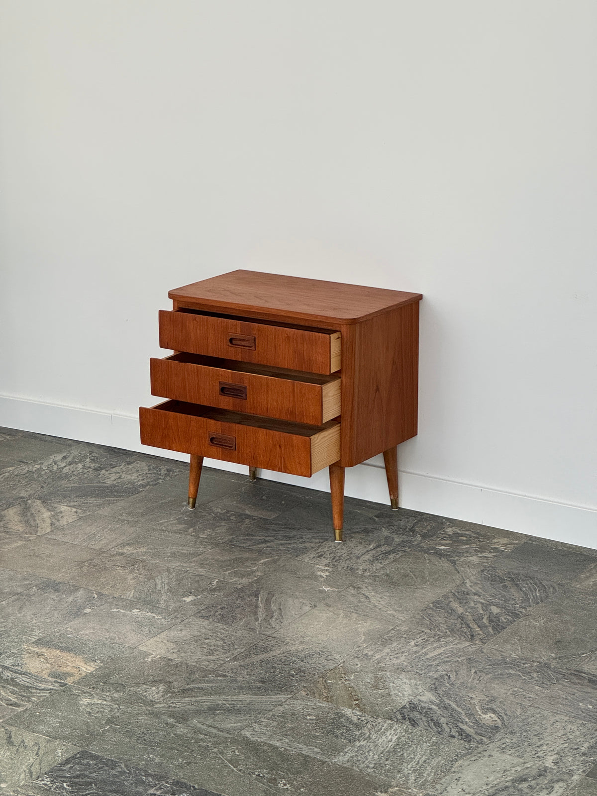 Mindre byrå/sängbord i teak, skålhandtag, tre lådor